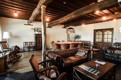 a living room with leather furniture and a table at Villa Vigor in Peer