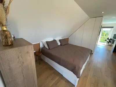 a bedroom with a bed in a room at Au cœur de l'Ardenne Bleue - Studio avec piscine in Baelen