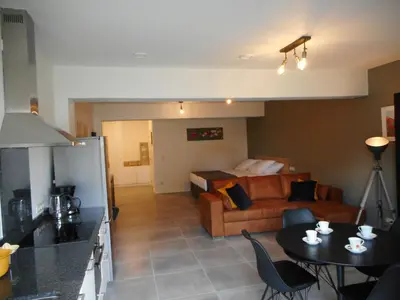 a kitchen and a living room with a couch and a table at De Hoog Velden 11 in Pelt