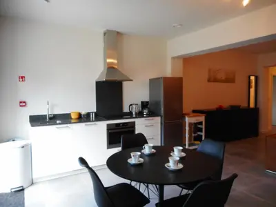 a kitchen with a table and chairs in a room at De Hoog Velden 11 in Pelt