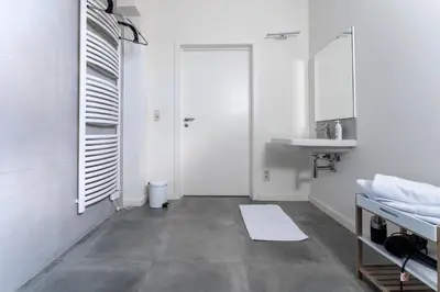 a white bathroom with a sink and a mirror at De Hoog Velden 11 in Pelt