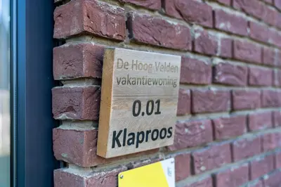 a sign on the side of a brick wall at De Hoog Velden 11 in Pelt
