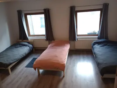 a room with two beds and two windows at Studio régence in Liège