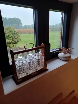 a window sill with four glass jars on it at Luxe-kamer Bed en Bokes in Drieslinter