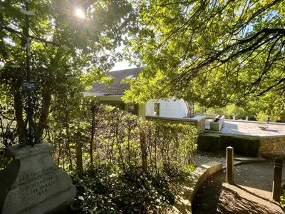 a grave in front of a house with a tree at La Bel échappée in Aubel