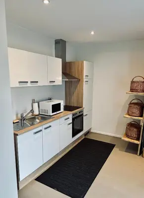 a kitchen with white cabinets and a microwave at La Bel échappée in Aubel