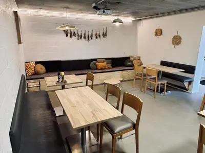 a restaurant with tables and a couch in the background at La Bel échappée in Aubel
