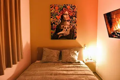 a bedroom with a bed with a painting on the wall at SuiteDreams-Jungle Suite - Liège in Liège