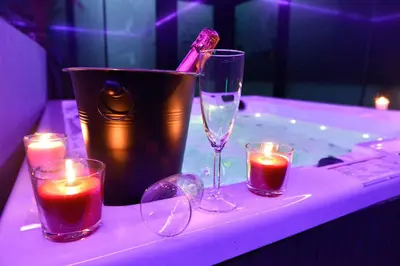 a table with three glasses and candles and a tub at SuiteDreams-Jungle Suite - Liège in Liège