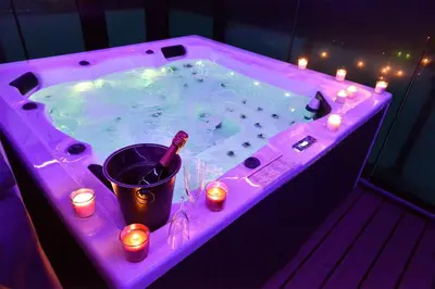 a hot tub with candles and lights in it at SuiteDreams-Jungle Suite - Liège in Liège
