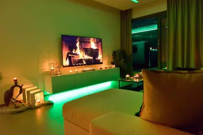 a living room with a bed and a flat screen tv at SuiteDreams-Jungle Suite - Liège in Liège