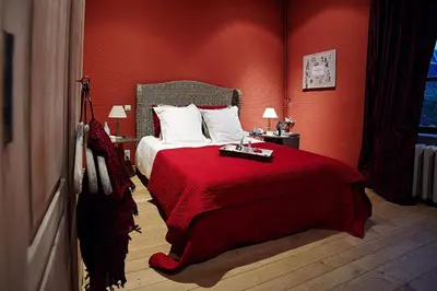 a red bedroom with a bed with a red blanket at B&B Au Clair Obscur in Verviers