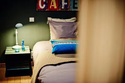 a bedroom with a bed and a table with a lamp at B&B Au Clair Obscur in Verviers