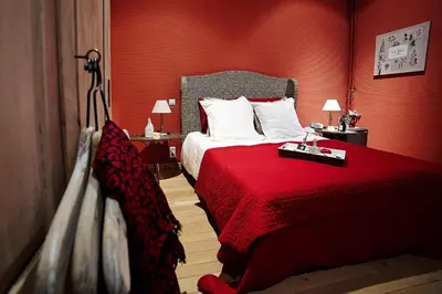 a hotel room with a bed with a red wall at B&B Au Clair Obscur in Verviers
