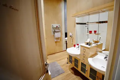 a bathroom with two sinks and a mirror at B&B Au Clair Obscur in Verviers