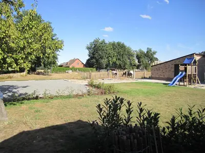 a playground with a blue slide in a yard at De Hoog Velden 13 in Pelt