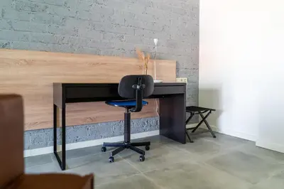 a desk with a chair in front of a brick wall at De Hoog Velden 13 in Pelt