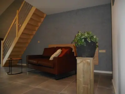 a living room with a couch and a potted plant at De Hoog Velden 13 in Pelt