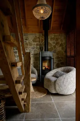 a living room with a fireplace and a stone wall at guesthouse Kamiele bij Lavendine Pure in Genk