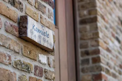 a sign on the side of a brick wall at guesthouse Kamiele bij Lavendine Pure in Genk