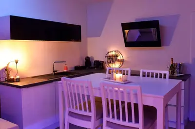 a kitchen with a white table with chairs and a sink at SuiteDreams - Sky Suite - Liège in Liège