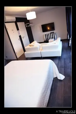 a room with two white beds and a living room at V E R O N E - Rooms & Suites - Liège - Rocourt in Liège