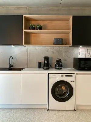 a kitchen with a washing machine and a sink at Shelter in Zutendaal