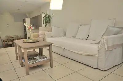 a living room with a white couch and a table at Holiday Home 't Regulierenhuisje in Tongeren