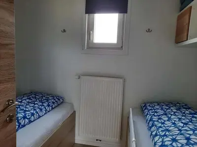a small room with two beds and a window at Hoeve Terwinghe in Gingelom