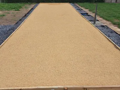 a walkway in a garden with gravel and grass at Hoeve Terwinghe in Gingelom