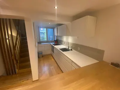 a kitchen with white cabinets and a sink at TRIPLEX NEUVICE in Liège