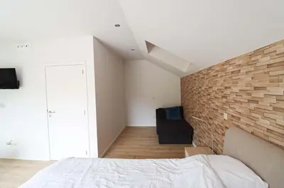 a bedroom with a brick wall and a bed at Recreatiedomein Warredal - The Lodge in Neeroeteren