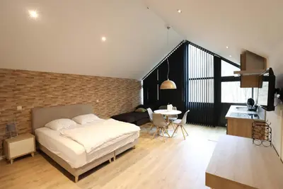 a bedroom with a bed and a brick wall at Recreatiedomein Warredal - The Lodge in Neeroeteren
