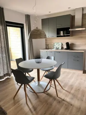 a kitchen with a table and chairs in a room at Recreatiedomein Warredal - The Lodge in Neeroeteren