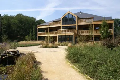 a large house with a walkway in front of it at Recreatiedomein Warredal - The Lodge in Neeroeteren