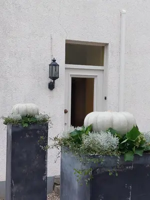 a house with two large pumpkins in front of a door at Entre Deux Eaux in Lanaken