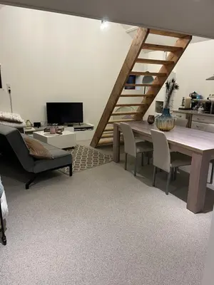 a living room with a table and chairs and a kitchen at Vakantiehuis de wereldburger Worldcitizen in Oudsbergen