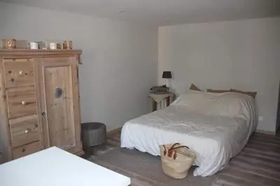 a bedroom with a bed and a dresser and a basket at La maison de Barbara in Aubel