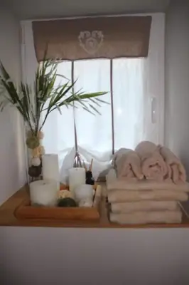 a shelf with towels and candles and a window at La maison de Barbara in Aubel