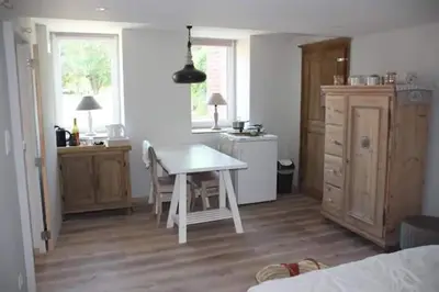a kitchen with a white table in a room at La maison de Barbara in Aubel
