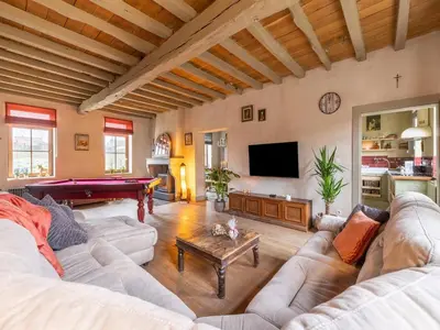 a living room with a couch and a pool table at Riding School Farm Stay in Sint-Truiden