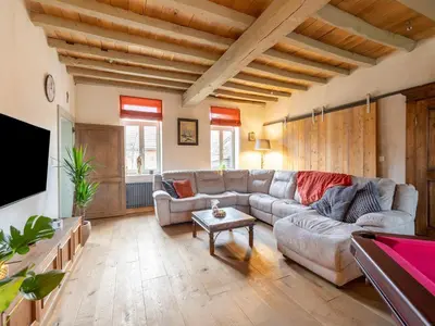a living room with a couch and a flat screen tv at Riding School Farm Stay in Sint-Truiden