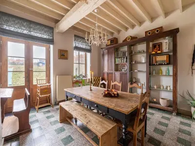 a dining room with a wooden table and chairs at Riding School Farm Stay in Sint-Truiden
