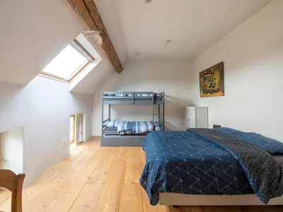 a bedroom with a bed in a room with a window at Riding School Farm Stay in Sint-Truiden
