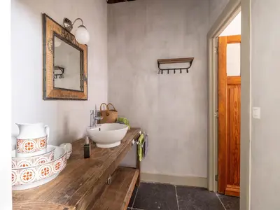 a bathroom with a sink and a mirror on a counter at Riding School Farm Stay in Sint-Truiden