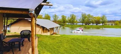 a boat in the water with a house and a boat at Camping de Boomgaard in Maaseik