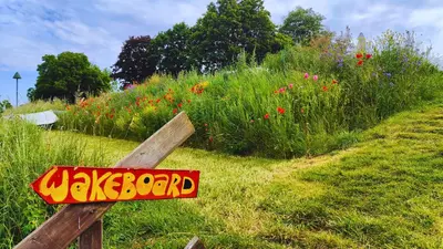 a sign that says wake board in front of a field of flowers at Camping de Boomgaard in Maaseik