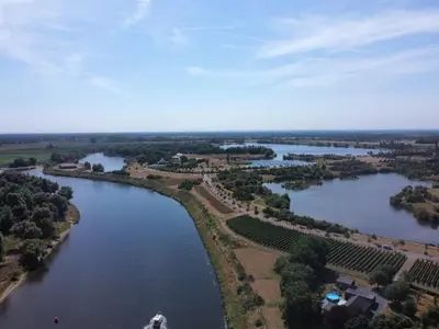 an aerial view of a river with buildings and trees at Camping de Boomgaard in Maaseik