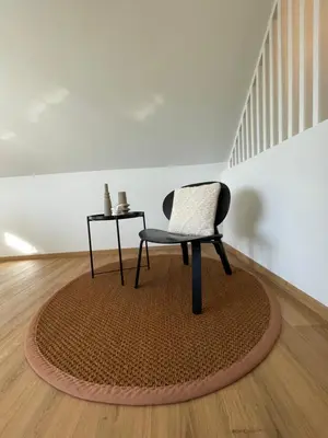 a chair and a table on a rug in a room at Vakantieappartement Logies Terhagen in Zoutleeuw