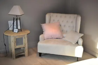 a chair with a pillow next to a side table at Hoeve Lavigne in Wellen
